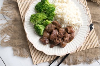 Beyaz pirinç üzerinde sığır eti ve brokoli Çin yemeği. hafif ahşap arka plan masasında