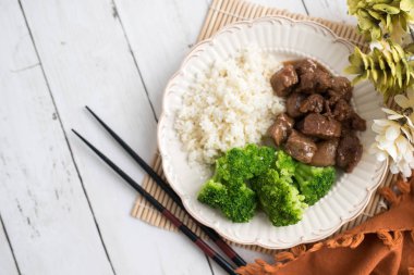 Beyaz pirinç üzerinde sığır eti ve brokoli Çin yemeği. hafif ahşap arka plan masasında