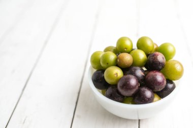 Muscadine üzüm de bataklık üzüm, ahşap arka plan üzerinde bir kase florida üzüm olarak bilinir