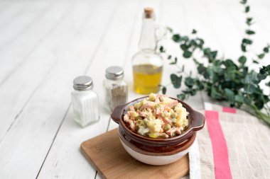 Bir kase geleneksel Rus salatası, adı Olivie, Rus Yeni Yılı ya da tahta arka planda Noel salatası. Pişmiş sebzelerden salata. Patates salatası.