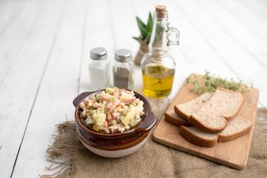 Bir kase geleneksel Rus salatası, adı Olivie, Rus Yeni Yılı ya da tahta arka planda Noel salatası. Pişmiş sebzelerden salata. Patates salatası.