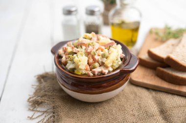 Bir kase geleneksel Rus salatası, adı Olivie, Rus Yeni Yılı ya da tahta arka planda Noel salatası. Pişmiş sebzelerden salata. Patates salatası.