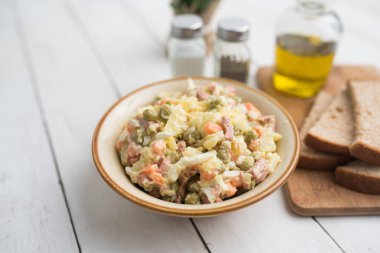 Bir kase geleneksel Rus salatası, adı Olivie, Rus Yeni Yılı ya da tahta arka planda Noel salatası. Pişmiş sebzelerden salata. Patates salatası.