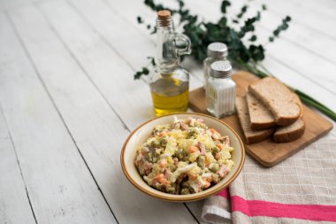 Bir kase geleneksel Rus salatası, adı Olivie, Rus Yeni Yılı ya da tahta arka planda Noel salatası. Pişmiş sebzelerden salata. Patates salatası.