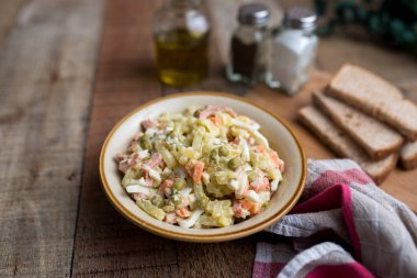 Bir kase geleneksel Rus salatası, adı Olivie, Rus Yeni Yılı ya da tahta arka planda Noel salatası. Pişmiş sebzelerden salata. Patates salatası.
