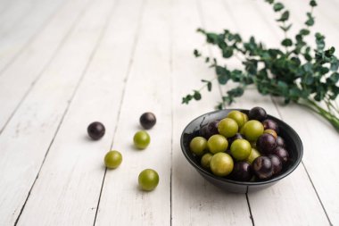 Muscadine üzüm de bataklık üzüm, ahşap arka plan üzerinde bir kase florida üzüm olarak bilinir