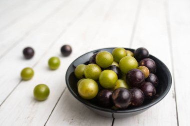 Muscadine üzüm de bataklık üzüm, ahşap arka plan üzerinde bir kase florida üzüm olarak bilinir