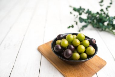 Muscadine üzüm de bataklık üzüm, ahşap arka plan üzerinde bir kase florida üzüm olarak bilinir