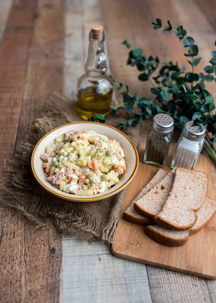 Bir kase geleneksel Rus salatası, adı Olivie, Rus Yeni Yılı ya da tahta arka planda Noel salatası. Pişmiş sebzelerden salata. Patates salatası.