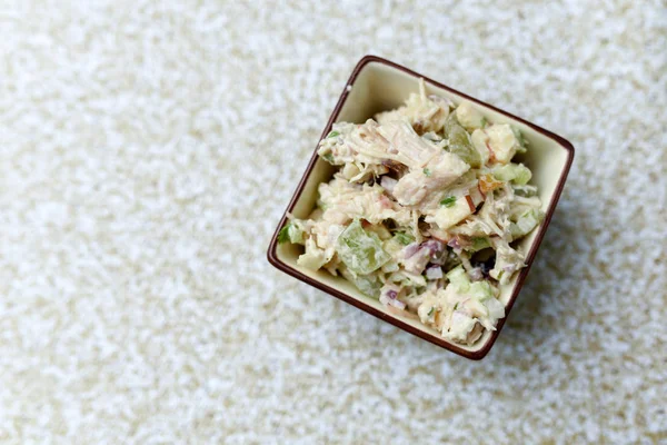 Salad dish with chicken apples nuts and cranberries in a small decorative side dish