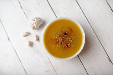 Beyaz ahşap zemin ve baharatlar üzerinde balkabağı sebze çorbası. Sonbahar hasat çorbası