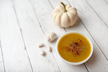 Beyaz ahşap zemin ve baharatlar üzerinde balkabağı sebze çorbası. Sonbahar hasat çorbası