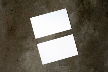 Marka kimliği için bir model. Boş beyaz kartvizitlerin fotoğrafı. Portföy ve proje sunumu için boş kartlar. Endüstriyel beton