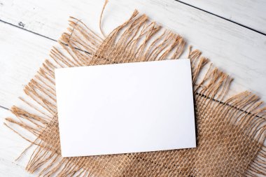 Marka kimliği için bir model. Boş beyaz kartın fotoğrafı. Portföy ve proje sunumu için boş kart. Klasik çuval bezi