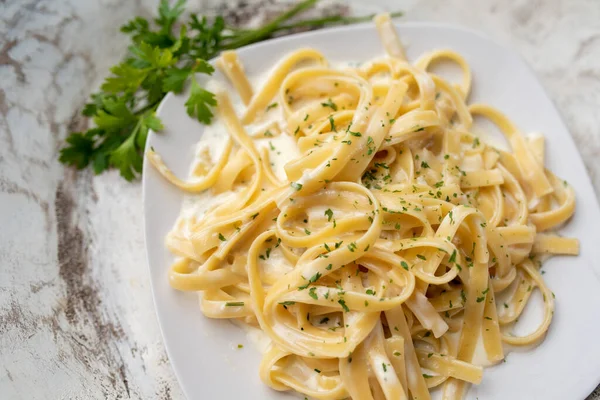 Alfredo pasta dinner with creamy white sauce and herbs