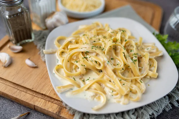 Alfredo pasta dinner with creamy white sauce and herbs