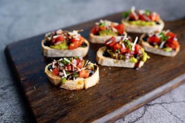 Brüksel sandiviçi domates, avacado, soğan ve balzamik jöleli aperatif olarak servis edilir.