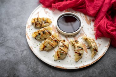 Çekirdek ve soğanla kaplanmış balzamik jöleli kızarmış yemek çubukları.