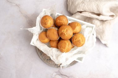 Tahta tepside kağıt kek tutacağının içinde mini kekler.