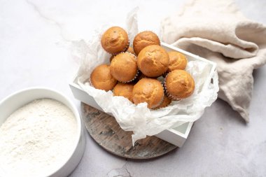 Tahta tepside kağıt kek tutacağının içinde mini kekler.