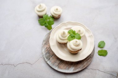 Tahta tepside beyaz krem peynirli kek tutacağı içinde mini kekler.