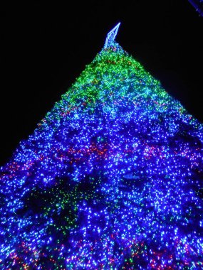 büyük bir yapay Noel ağacı ışıkları mavi ve yeşil renkleri ile bir gece çekimi