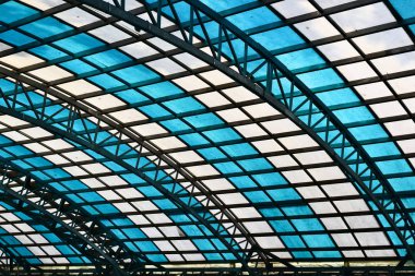 Sarai Rohilla tren istasyonunun bekleme salonunda beyaz ve mavi pencere hücreleri ile cam çatı, Delhi, Hindistan 