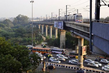 Delhi, Hindistan - Ekim 2016: Delhi metro treni demiryolu beton köprüsü ve akşam aşağıdaki yolda trafik sıkışıklığı