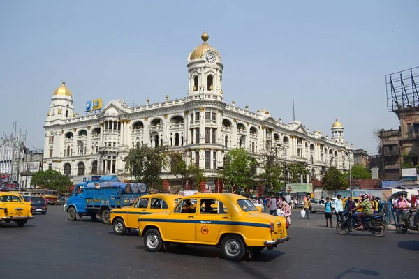 Kolkata, Hindistan-Mart, 2014: Esplanade 'deki Metropolitan Building 'in önünde kavşak üzerindeki araçlar ve insanlar. Calcutta 'nın tarihi bölgesinde saat kulesine sahip tarihi ev.