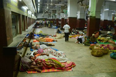 Kolkata, Hindistan-Mart, 2014: erkek ve kadınlar battaniye sarılmış bilet sayaçları yakın Howrah Tren İstasyonu binasında yerde uyku. Biletler için sırada duran diğer insanlar