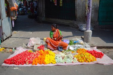 Kolkata, Hindistan-Mart, 2014: Hint kadın renkli çiçek çelenk iş parçacığı ve Puja (tapınakta Tanrılar çiçekler sunan yapmak için satış)