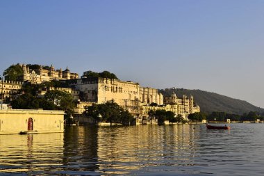 Pichola Gölü 'nün suda yansıtan Udaipur Şehir Sarayı 'nı görüntüleyin. Gün batımı zamanı. Udaipur da şehir olarak bilinen