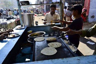 Jodhpur, Rajasthan, Hindistan-Aralık 2016: geleneksel sokak gıda satıcısı. Adam yemek Hint Chapati ile servis köri. Sabah kahvaltı zamanı