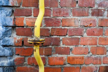 Tuğla duvar yakın çekim sarı eski gaz boru hattı. Ukrayna