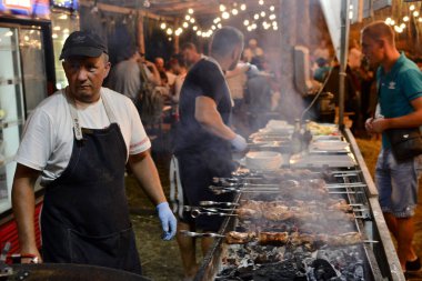 Velyki Sorochyntsy, Poltava Bölgesi, Ukrayna-Ağustos, 2016: ızgara et ile fuar pazarında gıda Stall Grill. Geleneksel Ukrayna pazarında sorochyntsi Fuarı 'nda Man Fries şiş kebab