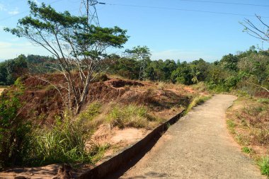 Kandy, Sri Lanka yakınlarındaki kayalıklar ile tepede ağaç ve beton yol