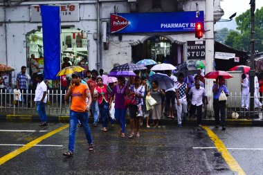 Kandy, Sri Lanka-Nisan, 2017: şehir merkezinde yaya geçiş Insanlar. Şehir merkezinde kalabalık bir cadde. Yağmurlu bir gün boyunca şemsiye ile insanların kalabalık.