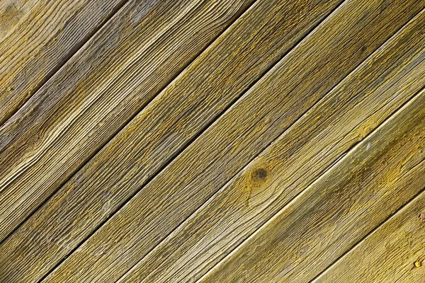 Wood texture. Rustic wooden planks placed by diagonal. Old weathered yellow boards.