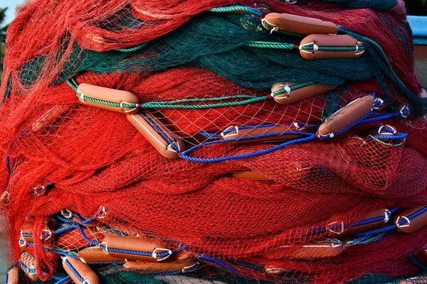 Heap of red fishermen nets equipment close-up on the beach near ocean. Weligama, Sri Lanka