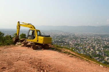 Pokhara Cityscape bir arka planda bir tepede kırık Ekskavatör makinesi ile inşaat sitesi. Nepal