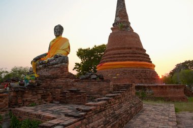 Eski Pagoda yakın Buddha eski heykel oturan ve bir gün batımı üzerinde son güneş Brights görünümü, Ayutthaya tarihi Parkı