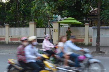 Hanoi, Vietnam - Eylül, 2015: Kaldırımda sokakta kalan bekçi. Motosikletsüren insanlar. Yolda bulanık hareket trafiği.