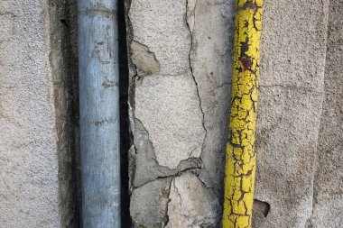 Beton çatlak duvar üzerinde eski boru hatları.