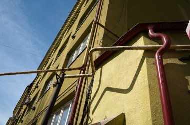 Sarı duvar arka plan üzerinde kırmızı borugölgeler. Şehir caddesinde açık havada parlak güneş ışığı.