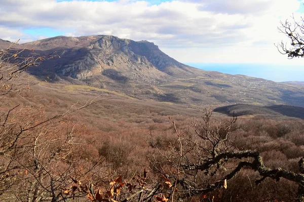 Crimea mountains in autumn, cloudy sky and sea on a background