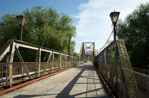 Walking bridge across river. Old rusty steel bridge. Galich, Ukraine