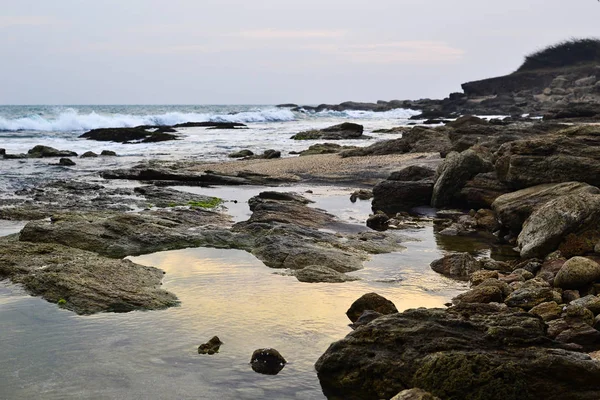 Duże Skały Plaży Fale Oceanie Zachód Słońca Niebo Odbija Się — Zdjęcie stockowe