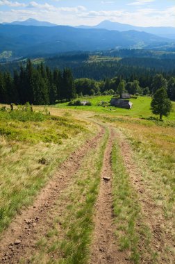 Dağlarda küçük bir eve yürüyüş parkuru. Dağ sırası ve vadilerin geniş açı görünümü. Ukrayna Karpatları en yüksek noktaları - Hoverla ve Petros zirveleri görünümü. Karpat dağları, Ukrayna.