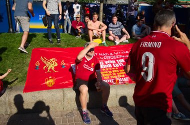 Kiev, Ukrayna - Mayıs 2018: Liverpool taraftarları Uefa Şampiyonlar Ligi Finali 2018 Liverpool v Real Madrid önce Khreshchatyk sokakta fan bölgesinde çim üzerinde oturan. Firmino adı ile t-shirt Adam.