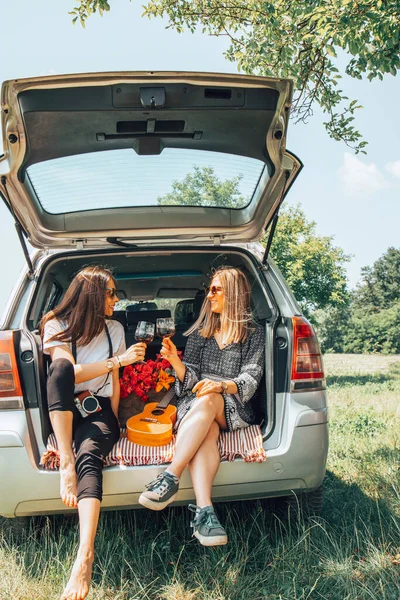 Two female friends travel around the world in a car. Vacation concept.